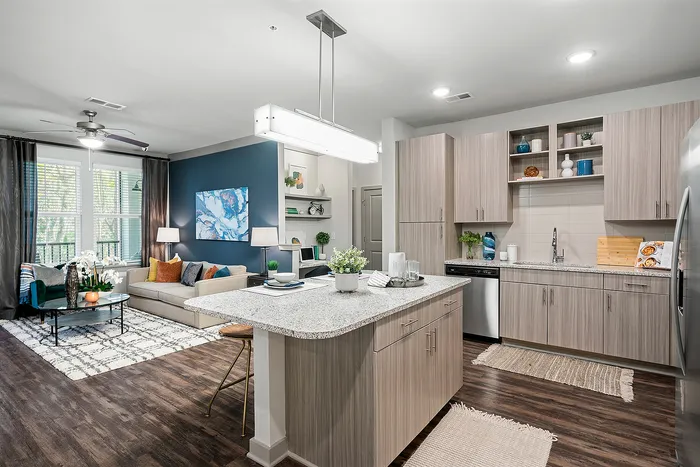 Modern open-concept kitchen and living area with sleek cabinetry, stylish island, and cozy seating, bathed in natural light.