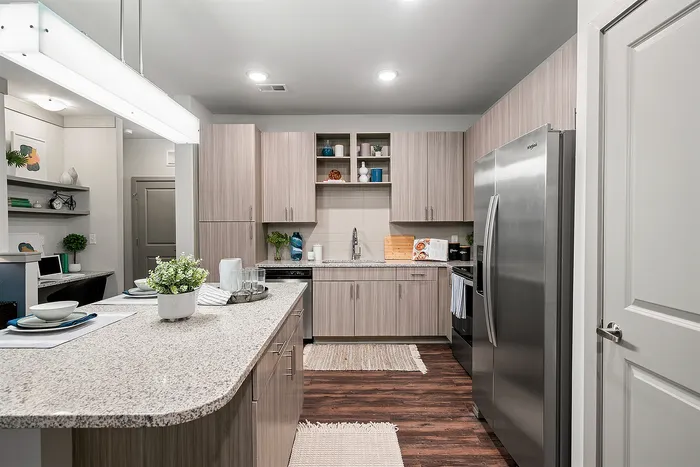 Modern kitchen design featuring sleek cabinetry, stainless steel appliances, and a stylish granite countertop with decor accents.