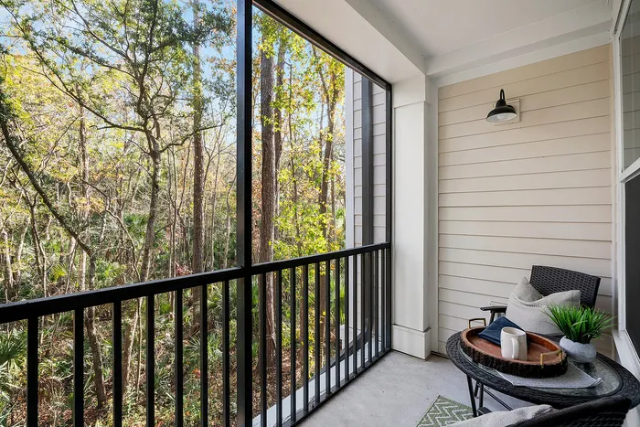 Tranquil balcony with a cozy seating area overlooking lush greenery, perfect for relaxation and enjoying nature views.
