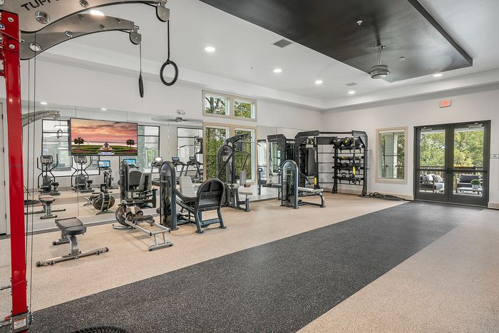 Modern fitness center featuring state-of-the-art exercise equipment, spacious layout, and abundant natural light with a scenic view.