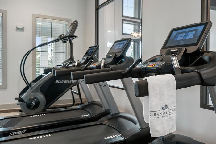 Modern fitness center with state-of-the-art treadmills, a stair machine, and a luxurious ambiance at Grande Oaks Park.