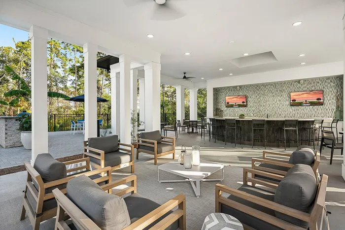 Luxurious outdoor lounge area featuring stylish seating, modern bar, and nature views, perfect for entertaining and relaxation.