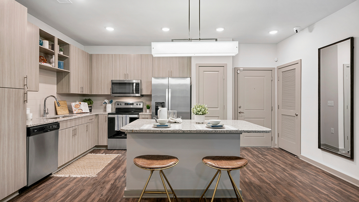 Modern kitchen with sleek cabinetry, stainless steel appliances, and a stylish island with seating. Ideal for culinary enthusiasts.