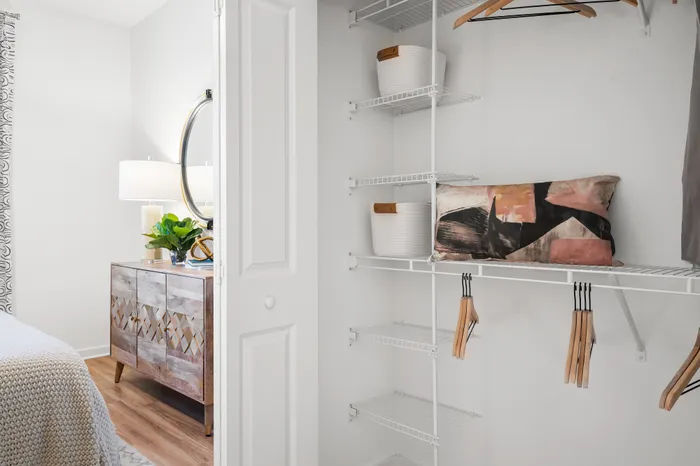 Inviting bedroom with sleek closet featuring organized shelves and modern decor.