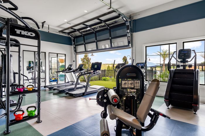 Contemporary fitness center with modern equipment, open layout, and expansive windows offering a refreshing outdoor view.