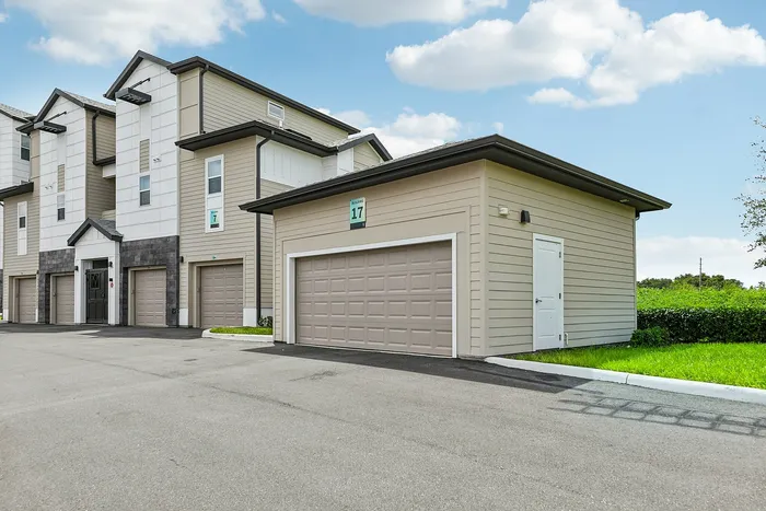 Modern apartment buildings with attached garages, showcasing sleek architecture and a well-maintained exterior on a sunny day.