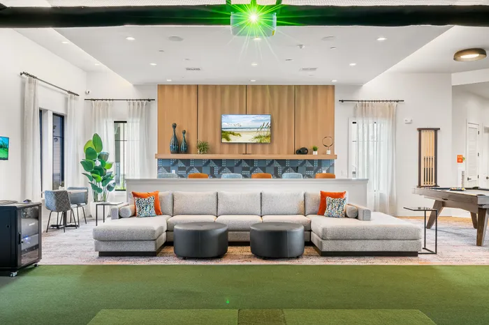 Modern and inviting living space with a plush sectional sofa, stylish decor, and a vibrant entertainment area. Ideal for relaxation and social gatherings.