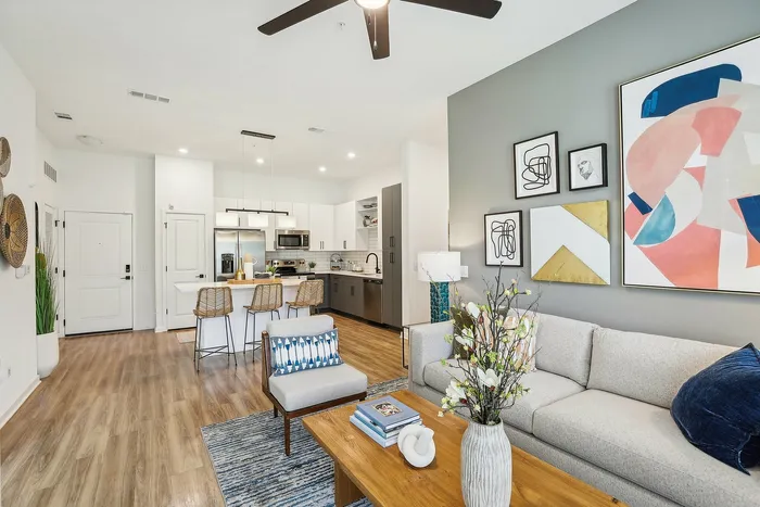 Bright, modern open-concept living space with sleek kitchen, stylish decor, and cozy seating area.