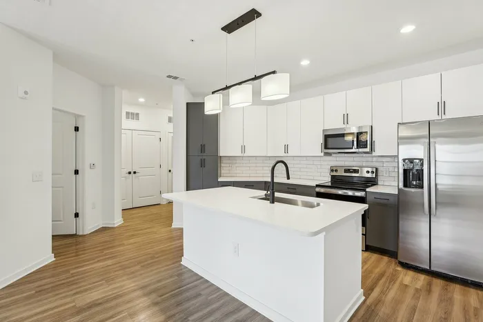 Modern kitchen with sleek cabinetry, stainless steel appliances, and elegant pendant lighting over a spacious island.