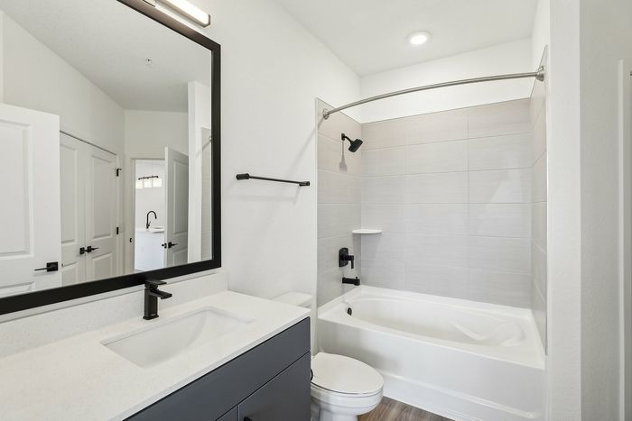 Modern bathroom design with sleek fixtures, a spacious bathtub, and stylish black accents for a luxurious feel.