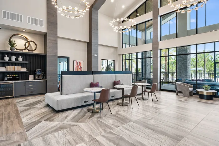 Modern and elegant lounge area with high ceilings, chic seating, and large windows providing a scenic view, perfect for relaxation or social gatherings.