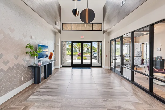 Elegant apartment lobby with modern decor, large windows, and stylish lighting, creating a welcoming and luxurious entrance.