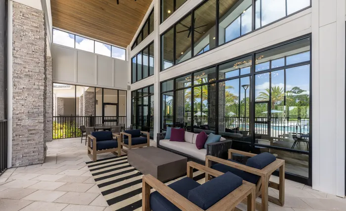 Inviting modern apartment lounge with elegant seating, large windows, and a scenic outdoor view.