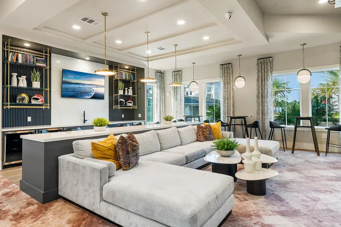 Luxurious living room with modern L-shaped sofa, elegant decor, and large windows offering scenic views.
