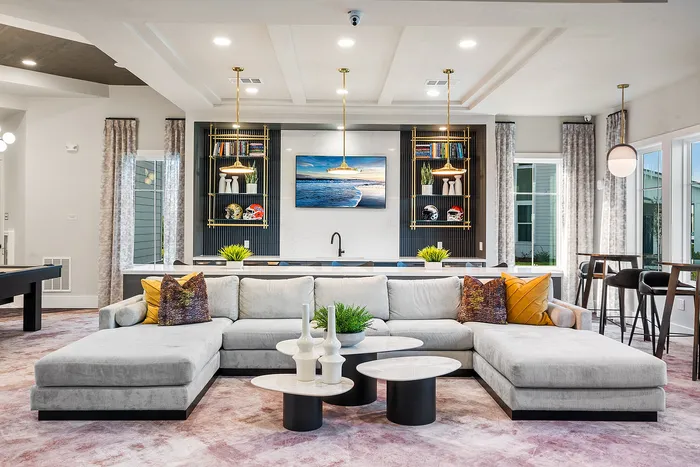 Luxurious open-concept living room with stylish sectional sofa, modern decor, and elegant lighting.
