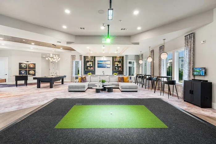 Luxurious and spacious open-concept living area showcasing a modern entertainment room with a pool table, stylish bar seating, and a cozy sectional sofa.