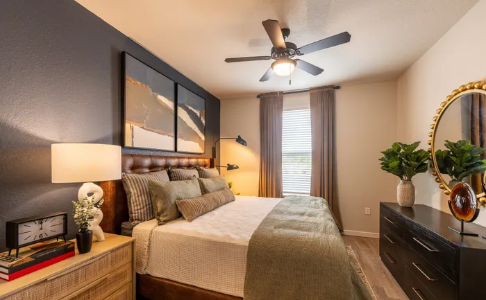 Inviting bedroom with elegant decor, featuring a plush bed, modern lighting, stylish artwork, and a soothing color palette. Perfect for relaxation and comfort.