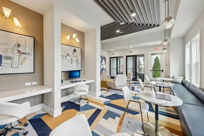 Contemporary co-working space featuring sleek workstations, modern art, and comfortable seating with vibrant geometric flooring.