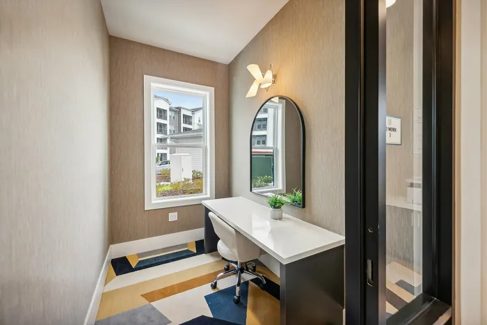 Bright home office nook with modern desk, comfortable chair, and stylish decor, showcasing large window with outdoor view.
