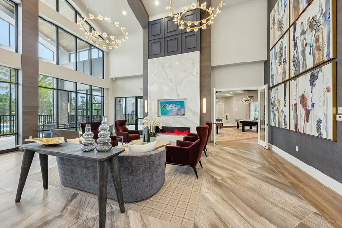 Luxurious lobby with modern chandeliers, elegant seating, and large windows offering garden views.