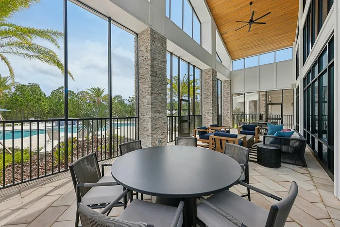 Elegant outdoor seating area with modern furnishings and lush palm views, perfect for relaxation and entertaining.