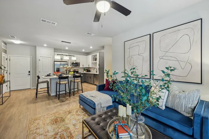 Modern open-concept living space featuring a stylish kitchen, cozy lounge with vibrant decor, and elegant lighting.