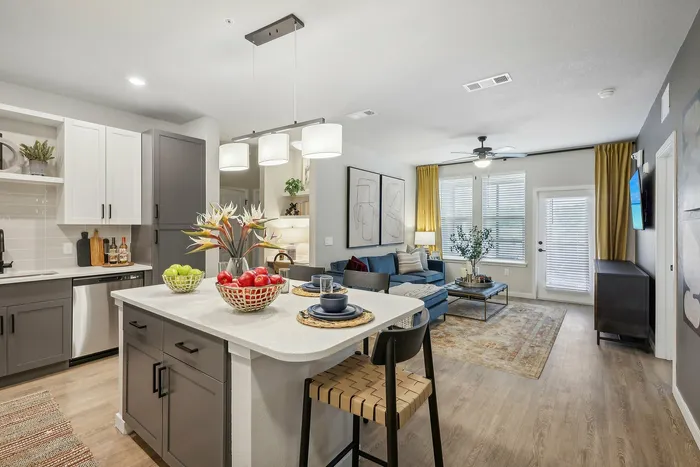 Elegantly designed open-concept kitchen and living area featuring a modern island, stylish decor, and abundant natural light.