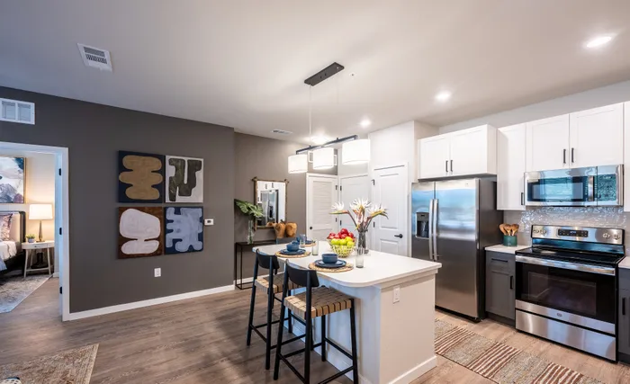 Modern open kitchen with sleek stainless steel appliances, contemporary lighting, and stylish bar seating, perfect for entertaining.