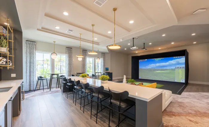 Contemporary entertainment room with sleek bar seating, elegant lighting fixtures, and a state-of-the-art golf simulator, ideal for relaxation and socializing.