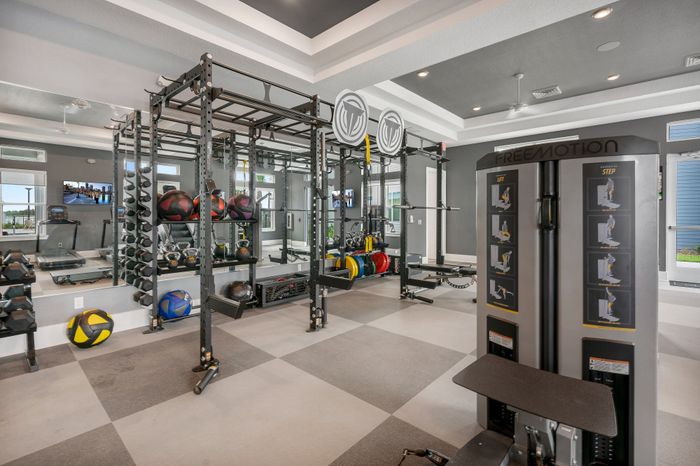 Modern fitness center featuring state-of-the-art equipment, free weights, and ample natural light for an invigorating workout experience.