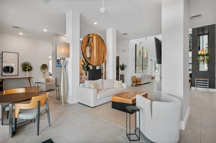 Stylish and modern apartment interior showcasing a spacious open-plan living area with elegant decor, featuring a cozy white sofa, contemporary wooden accents, and artistic wall pieces.