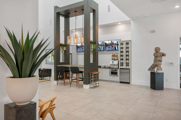 Contemporary community space featuring modern decor, elegant lighting, and a stylish sculpture, perfect for social gatherings.