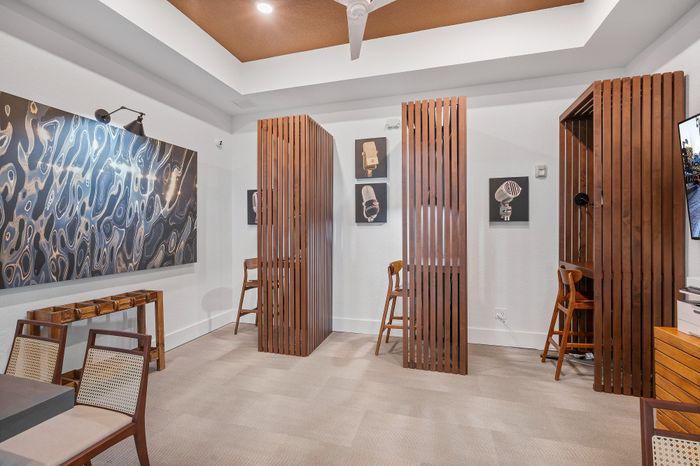 Chic modern office space with stylish wooden partitions, elegant wall art, and comfortable seating for a creative work atmosphere.