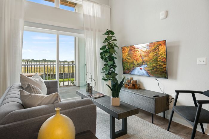 Apartments Near Orlando &ndash; 14Fifty Neo &ndash; Living Area With Vaulted Ceiling, Hardwood-Inspired Flooring, And Floor-To-Ceiling Windows.