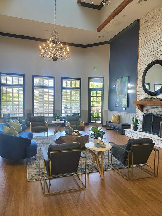 Elegant living room with high ceilings, stylish chandelier, and cozy seating arrangement around a modern fireplace.