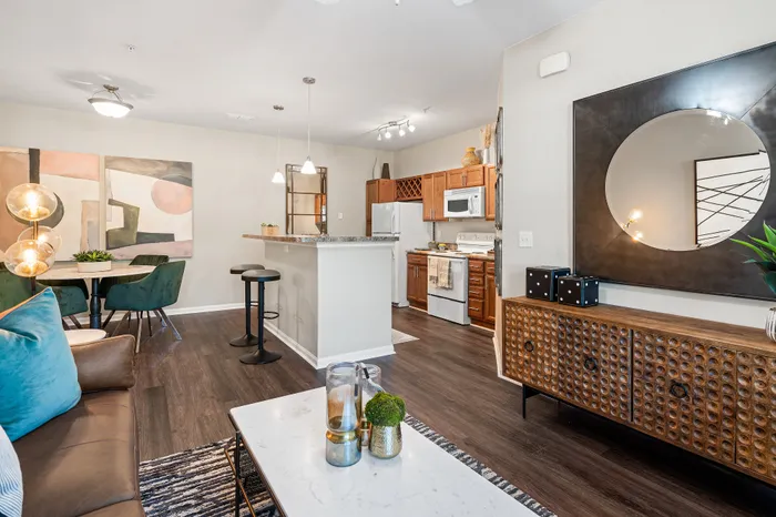 Chic open-concept apartment featuring modern kitchen with breakfast bar, cozy living area, and elegant dining space with artistic decor.