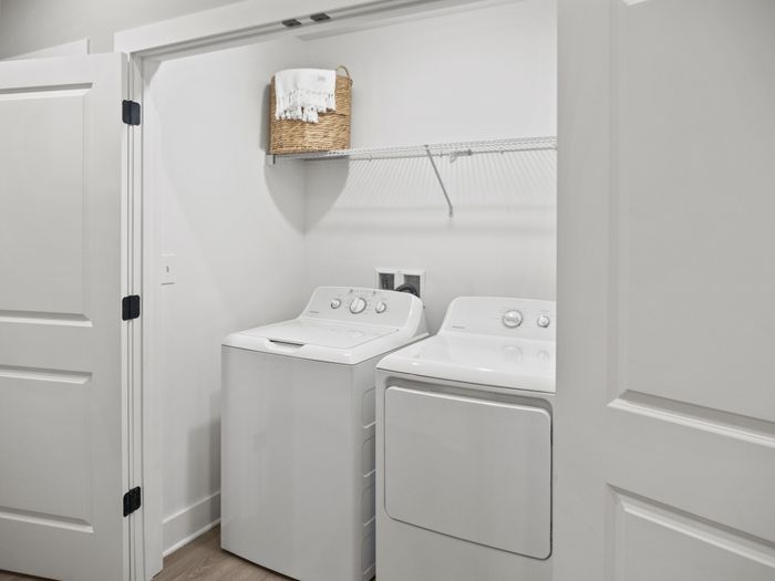 Sleek apartment laundry closet showcasing contemporary washer and dryer with elegant shelving.