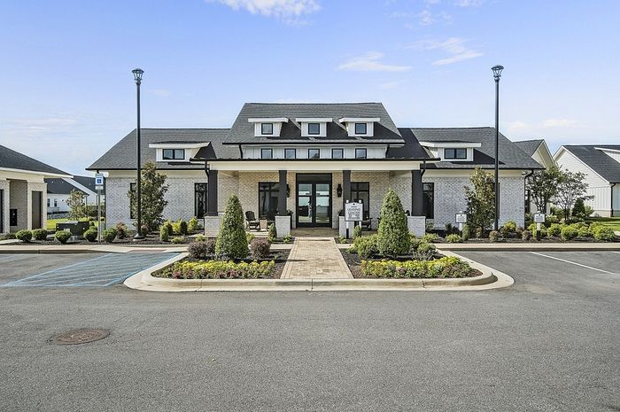 Elegant leasing office with charming landscaping and modern architecture under a bright blue sky.