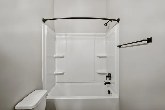 Modern bathroom featuring a stylish white bathtub and sleek black fixtures, offering clean lines and contemporary elegance.