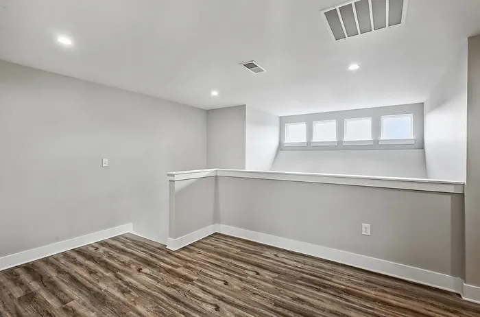 Bright modern room with elegant wood flooring and natural light streaming through windows.