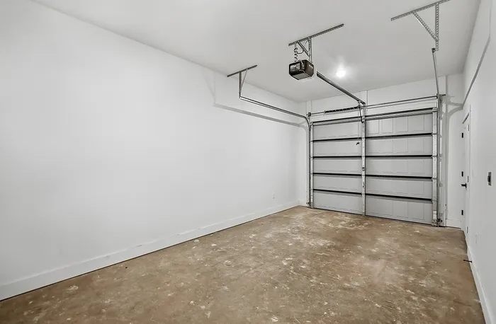 Spacious modern garage with sleek white walls and ample storage potential.