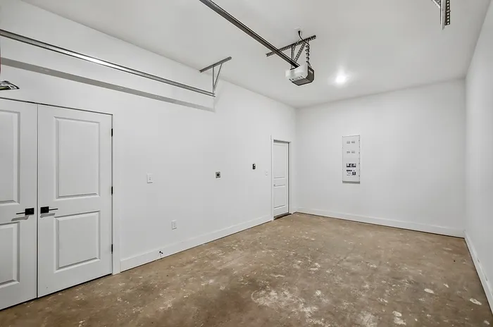 Bright and spacious garage with polished concrete floors, modern white walls, and ample storage potential.
