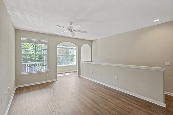Bright and airy living space with large windows and elegant wooden flooring, perfect for modern living.