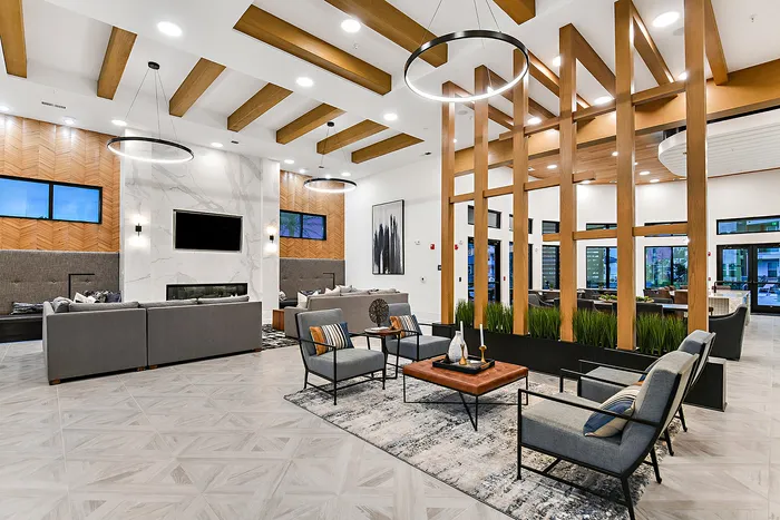 Luxurious modern lounge featuring elegant seating, stylish lighting, and a sophisticated ambiance with wooden accents and lush greenery.