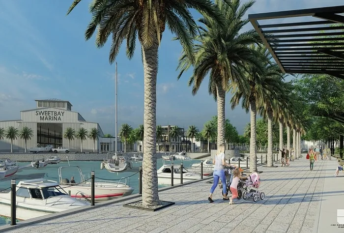 Vibrant waterfront promenade adorned with palm trees, families strolling, and boats docked near Sweetbay Marina under a clear blue sky.