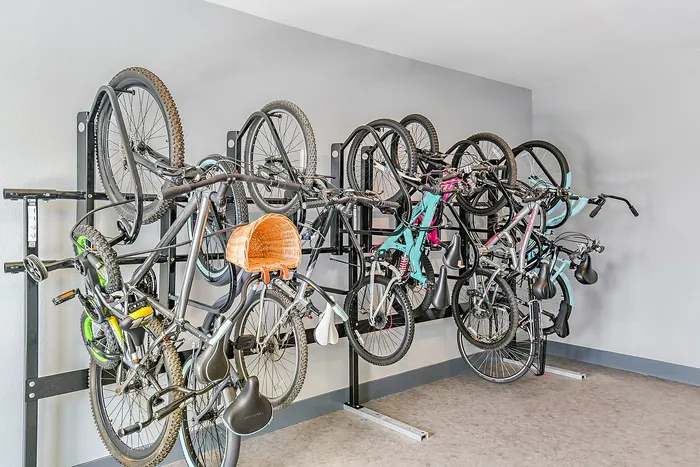 Modern apartment complex bike storage showcasing efficient vertical racks with multiple bicycles, highlighting convenient and stylish urban living amenities.