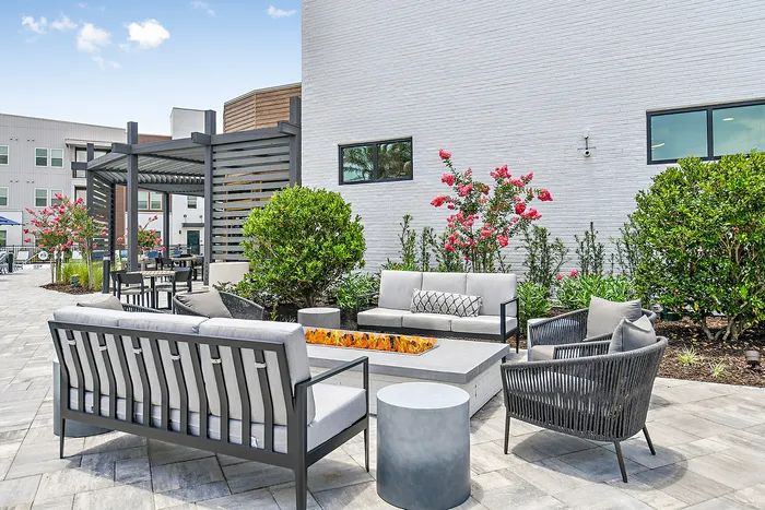 Chic outdoor patio with modern seating, cozy fire pit, and vibrant garden ambiance.