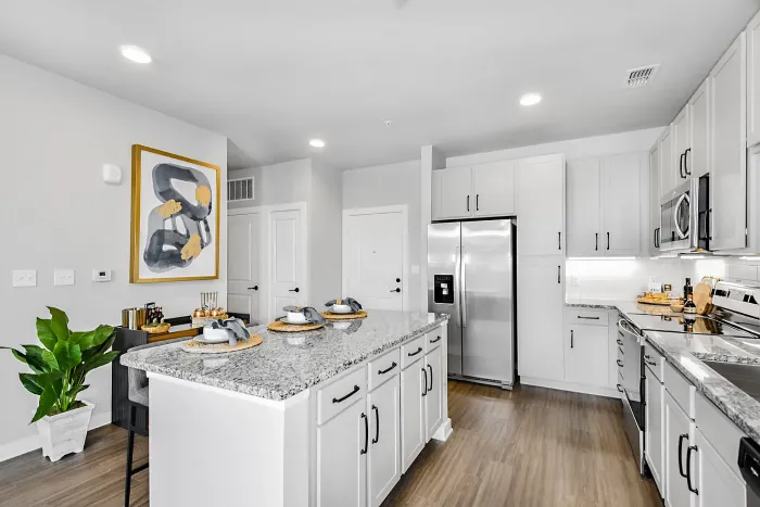 Modern kitchen with sleek white cabinetry, stainless steel appliances, and elegant granite countertops, perfect for culinary creativity.