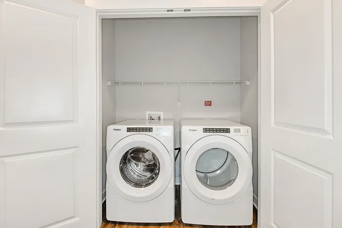 Modern laundry closet with high-efficiency washer and dryer, sleek design, and ample storage space.