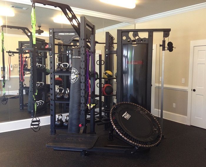 Modern fitness room featuring state-of-the-art gym equipment, including kettlebells, a punching bag, and a trampoline, ideal for a complete workout experience.